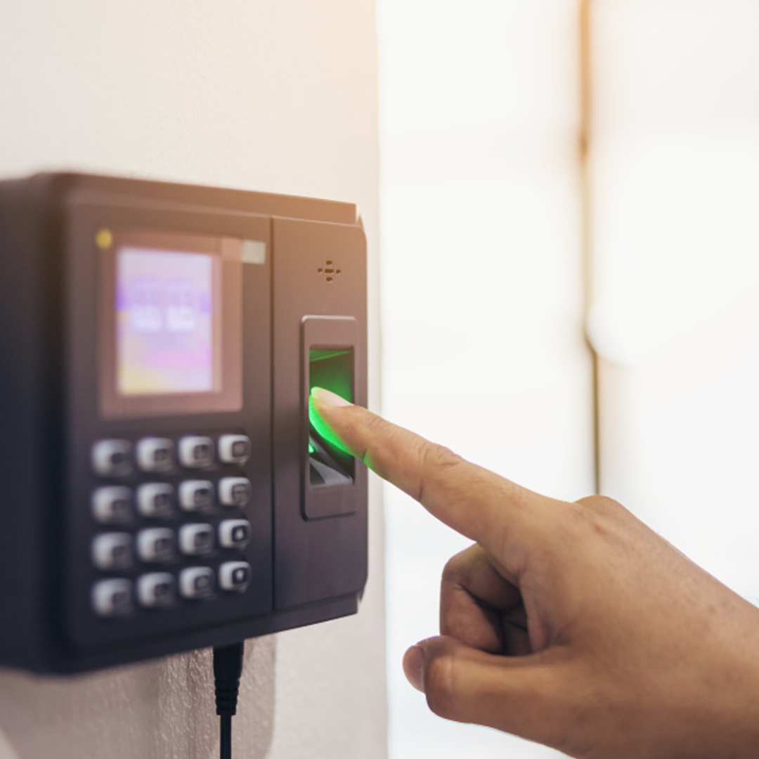 Pessoa utilizando um leitor biométrico para registro de ponto com impressão digital em equipamento de controle de acesso.